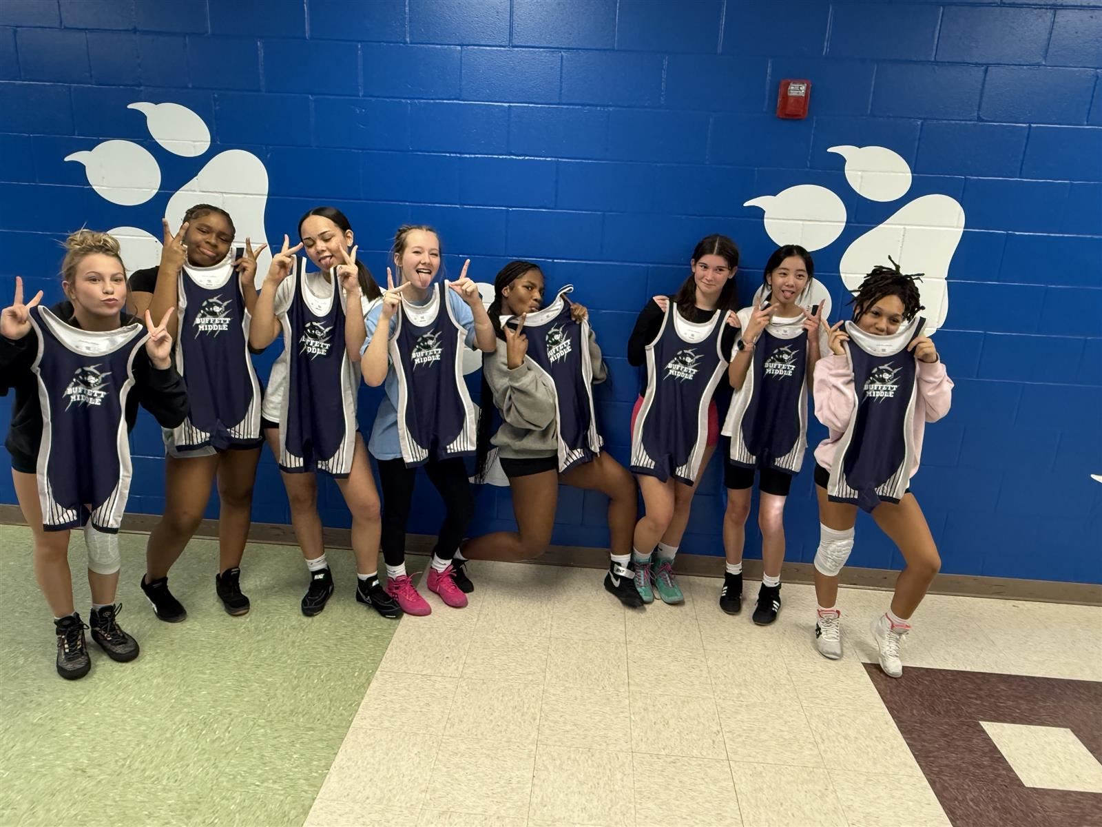  wrestling girls holding their new singlets